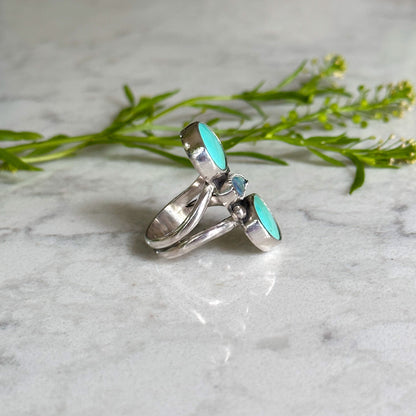 Side perspective of Handcrafted silver ring featuring an oval turquoise stone, set in an intricate bohemian-inspired band, showcasing natural patterns.